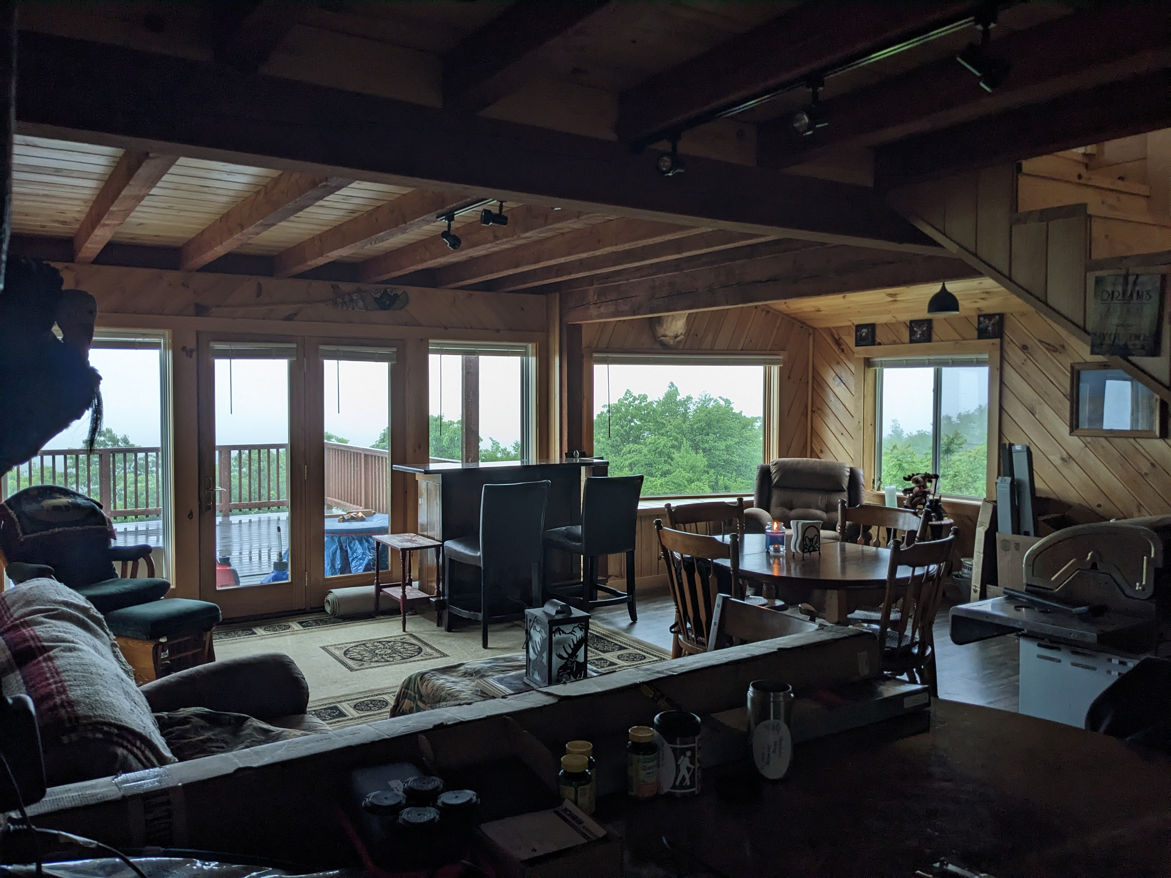 Interior of the great room: timber beams, dining table, and sliding doors out to the view